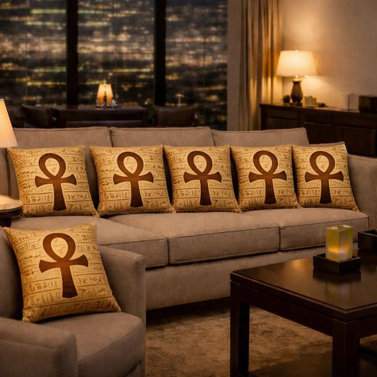 Gray sofa with decorative pillows featuring ankh symbol in a room with cityscape view